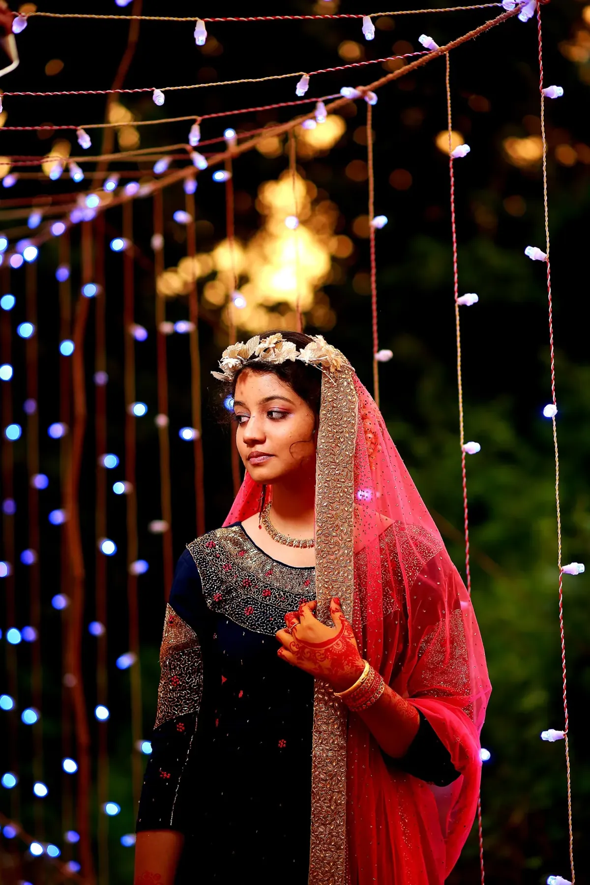 Bride under fairy lights at an evening celebration